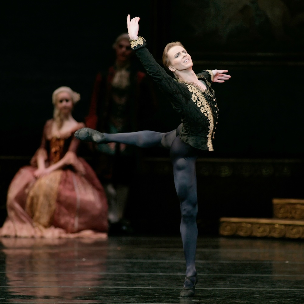 Dancer Tiit Helimets performs as Siegfried in Swan Lake. He wears a black costume with gold accents